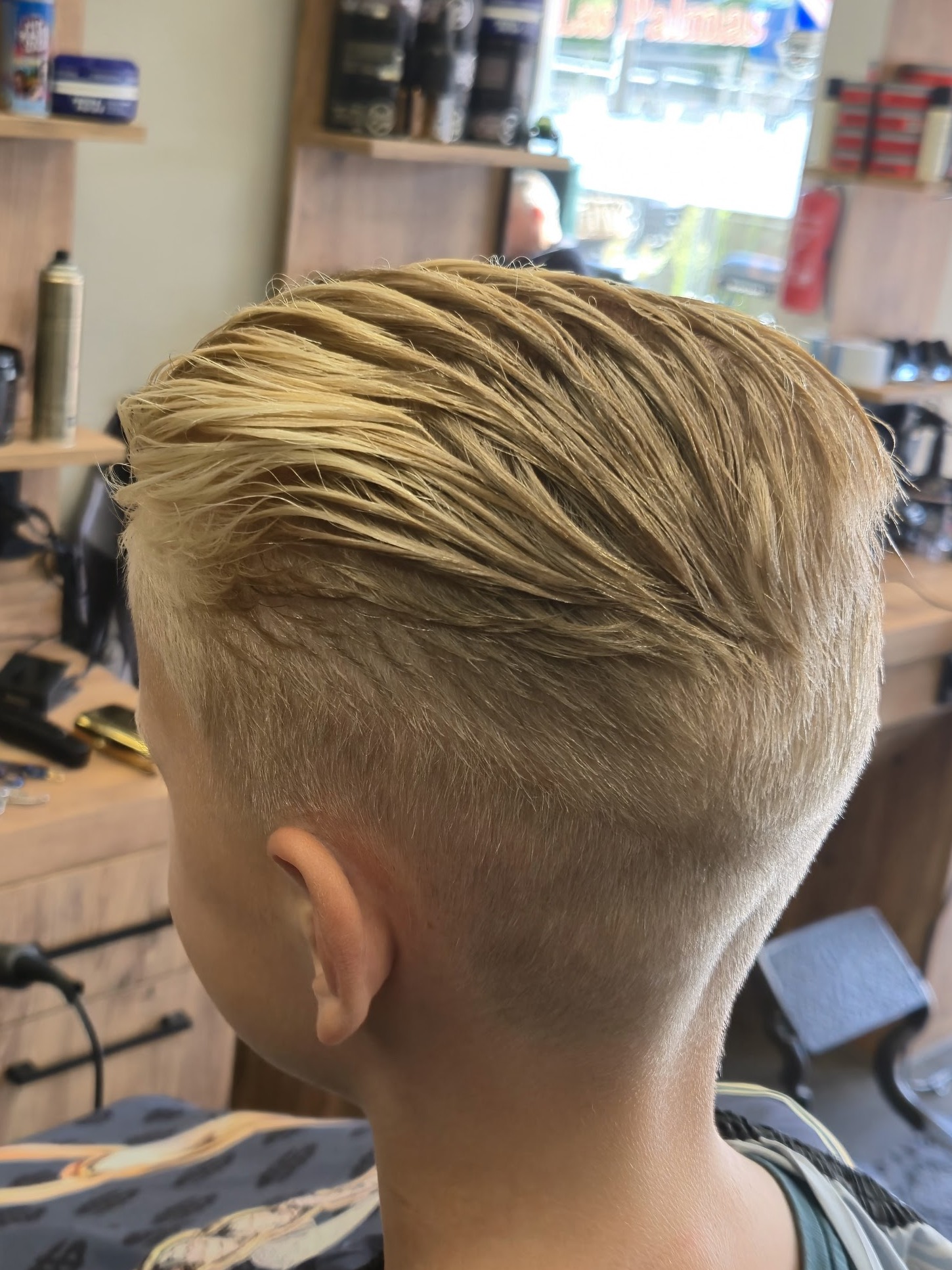 Blond kapsel met kort geknipte zijkanten en langer haar bovenop